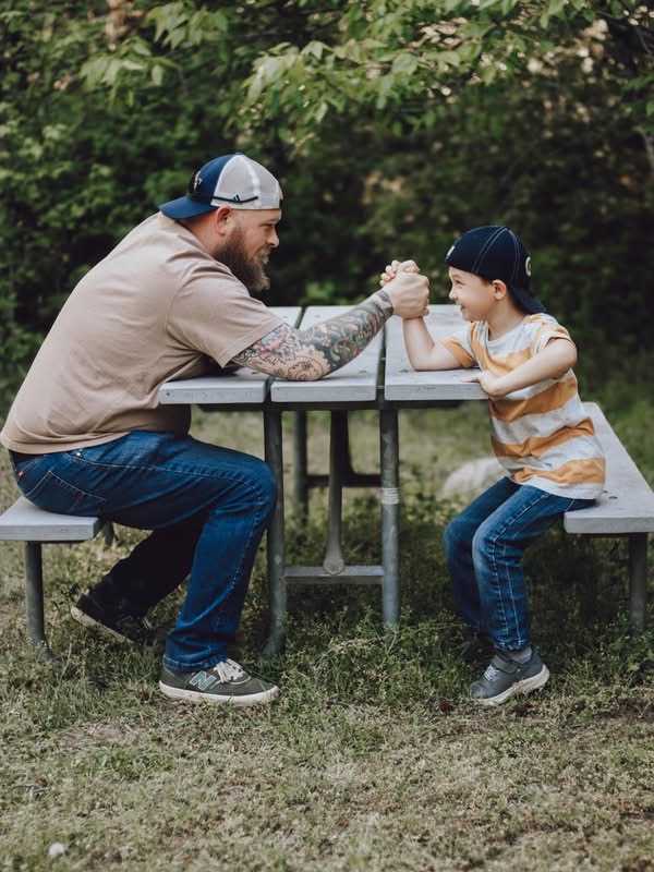 Father and son sharing a playful moment at a picnic table